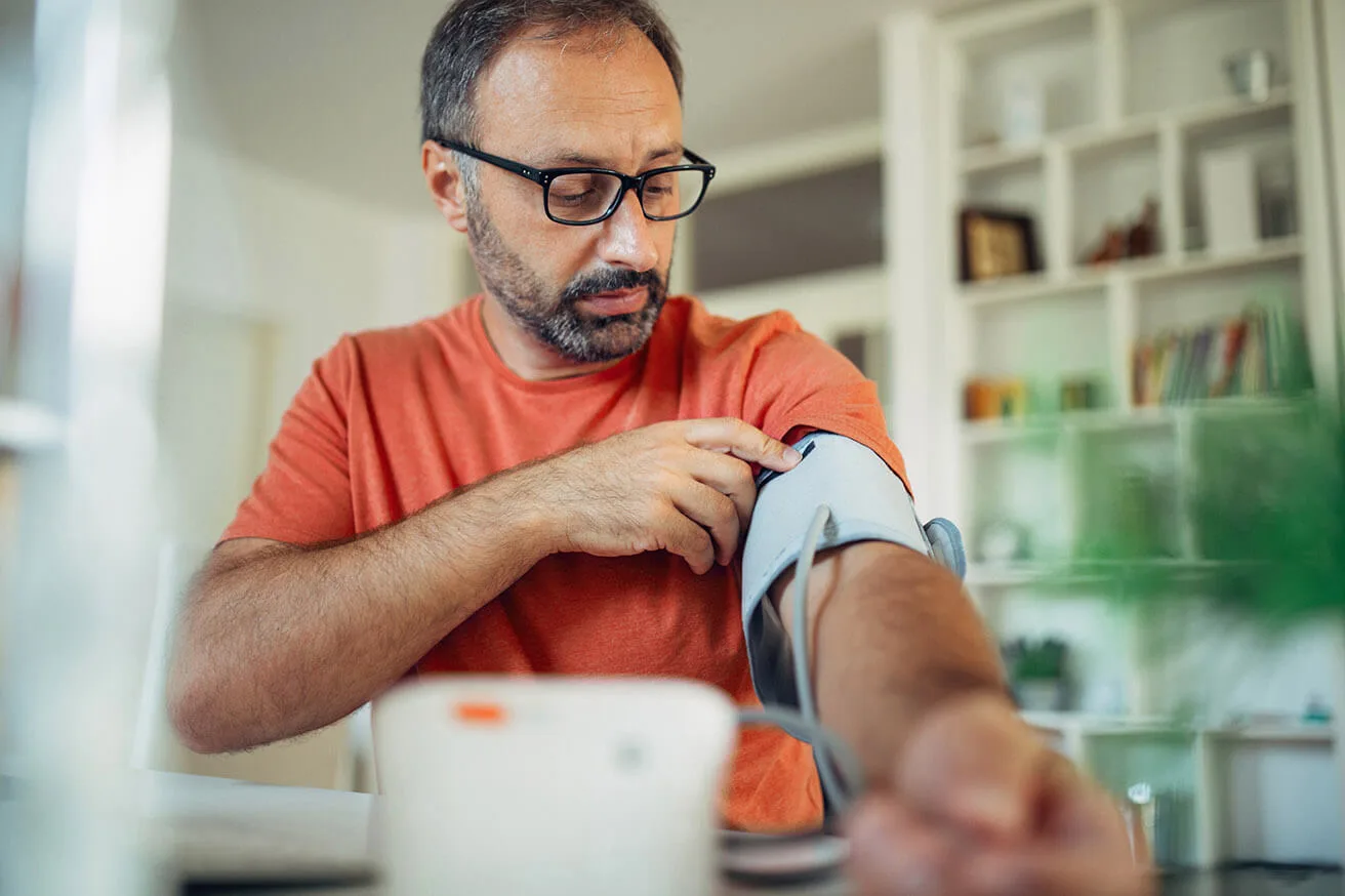 Patients & public - Man at home takes blood pressure