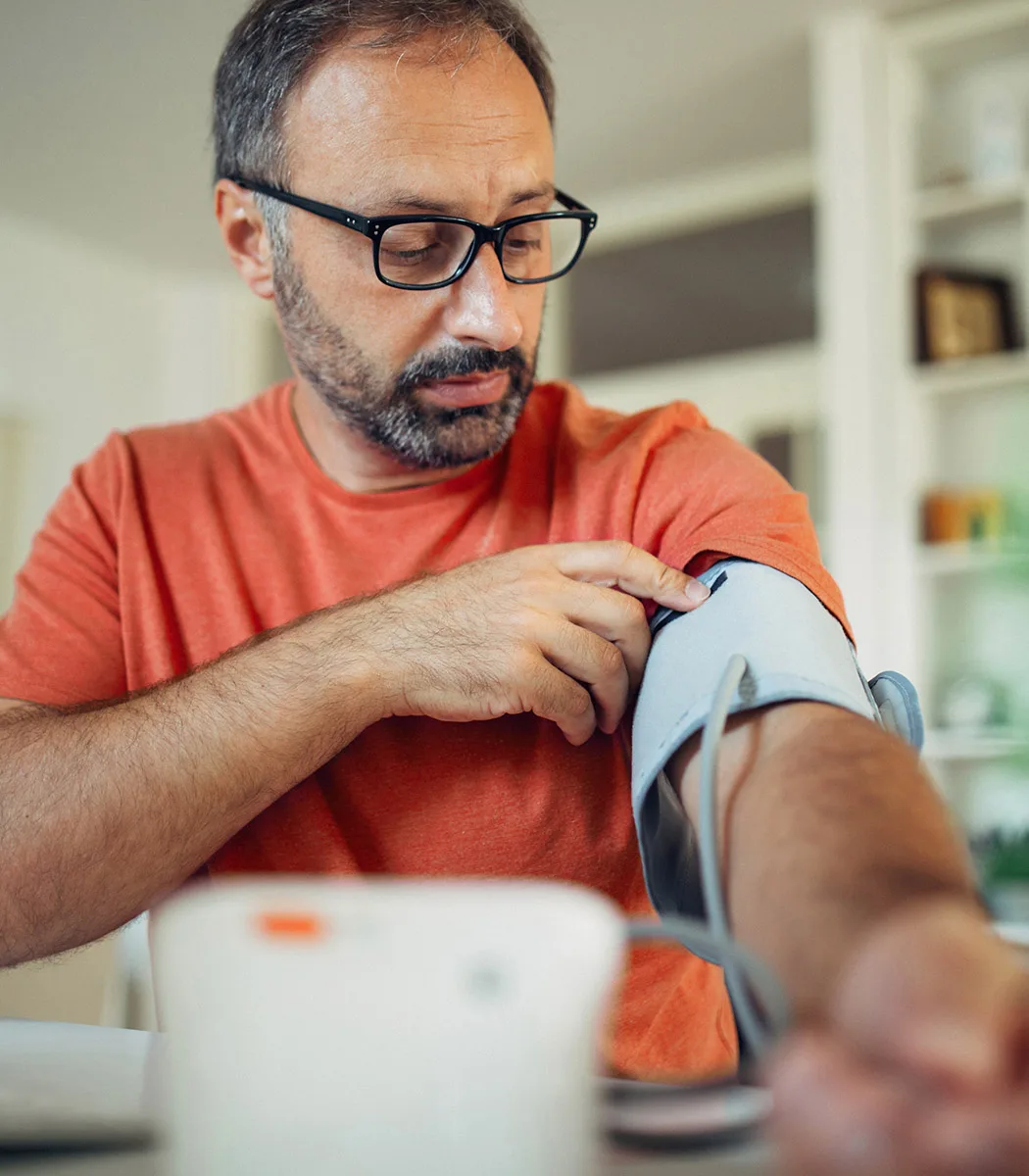 Man at home takes blood pressure