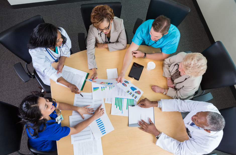 Group of healthcare professionals discussing data round a table