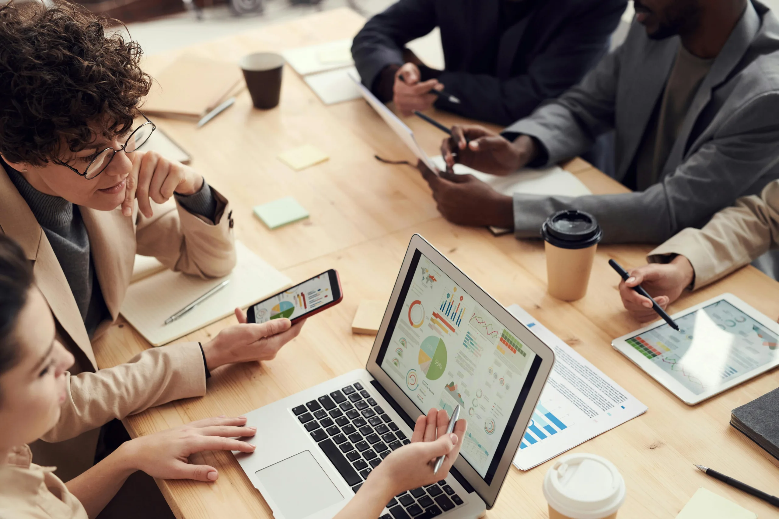 Group of people in a meeting looking at a screen with data